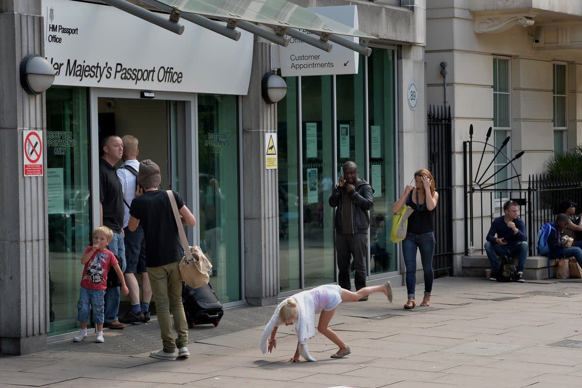 Collect an application form from a post office, fill it out and turn up at a passport office, such as the one in Victoria, London, for a pre-booked appointment with two photos (PA)