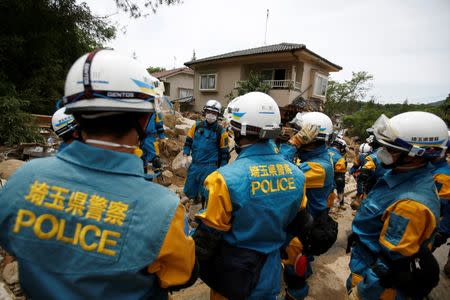 Rescue workers and Japan Self-Defense Force soldiers search for missing people at a landslide site after heavy rain in Kumano Town, Hiroshima Prefecture, western Japan, July 11, 2018. REUTERS/Issei Kato