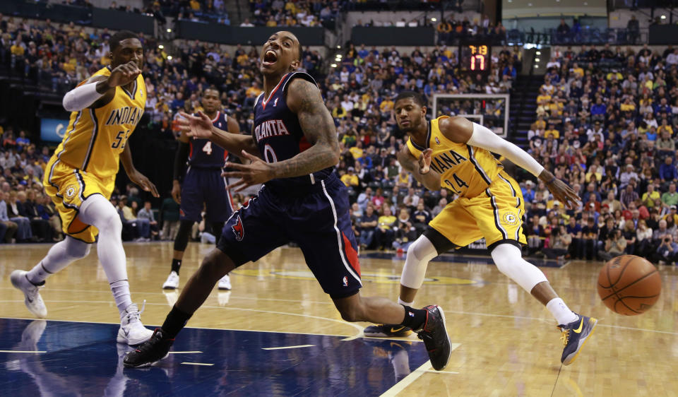 Atlanta Hawks guard Jeff Teague reacts after losing the basketball as Indiana Pacers forward Paul George, right, and Pacers center Roy Hibbert, left, defend in the first half of an NBA basketball game in Indianapolis, Sunday, April 6, 2014. Atlanta won 107-88. (AP Photo/R Brent Smith)