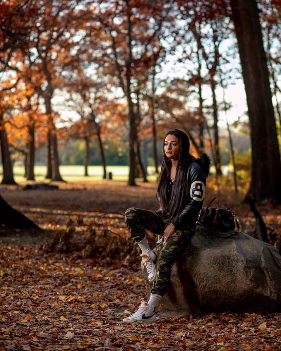 Julisa Abad sits on a rock in a wooded area.