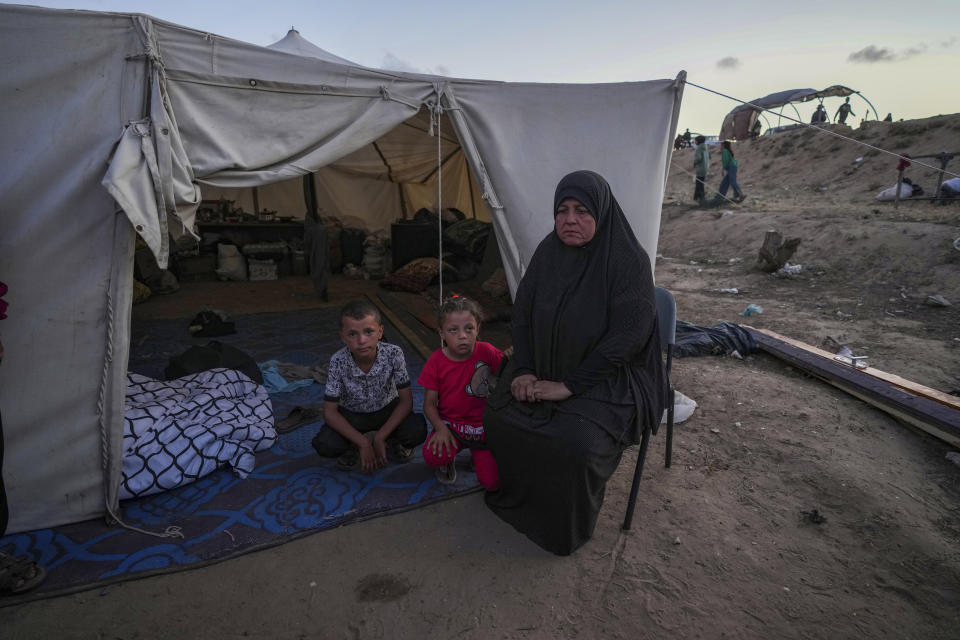 Una mujer palestina se sienta ante su carpa improvisada con sus nietos, tras verse desplazados por la ofensiva aérea y terrestre de Israel en la Franja de Gaza, en un campamento en Deir al balah, el lunes 13 de mayo de 2024. Los palestinos conmemoraban el miércoles el 76to año desde su expulsión masiva de lo que ahora es Israel, un suceso en torno al que gira su lucha nacional. Pero en muchos aspectos, esa experiencia palidece en comparación con la calamidad que se produce ahora en Gaza. (AP Foto/Abdel Kareem Hana)