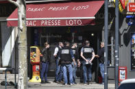 Police officers gather after a man wielding a knife attacked residents venturing out to shop in the town under lockdown, Saturday April 4, 2020 in Romans-sur-Isere, southern France. The alleged attacker was arrested by police nearby, shortly after the attack. Prosecutors did not identify him. They said he had no documents but claimed to be Sudanese and to have been born in 1987. (AP Photo)
