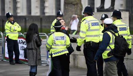 Police move a demonstrator as Israel's Prime Minister Benjamin Netanyahu arrives to visit Britain's Prime Minister Theresa May at Downing Street in London, Britain, February 6, 2017. REUTERS/Dylan Martinez