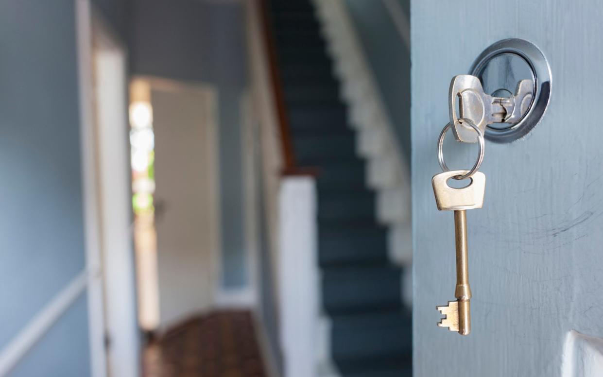 Key in door opening up to a home hallway