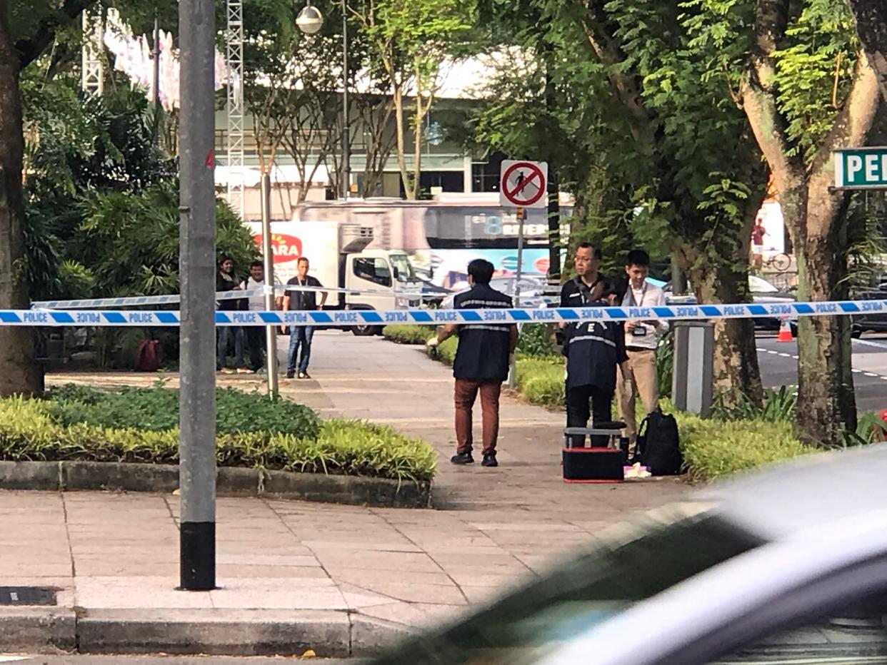 A police officer is seen removing the suspicious item. PHOTO: Yahoo News Singapore