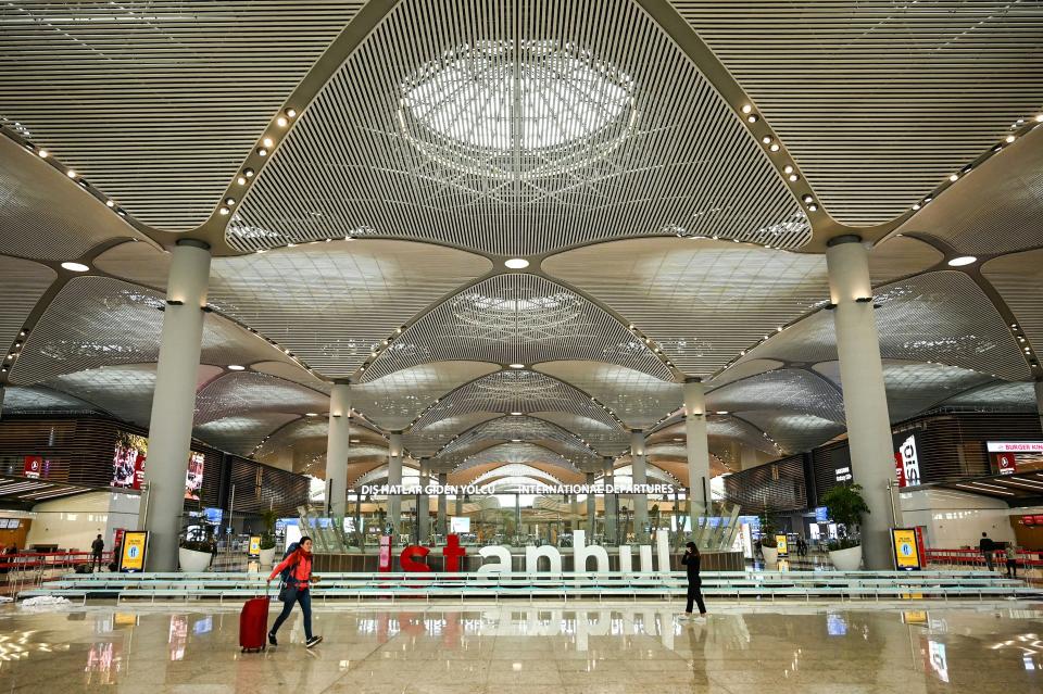 People are walking in Istanbul airport with the "Instabul" sign in the center frame.