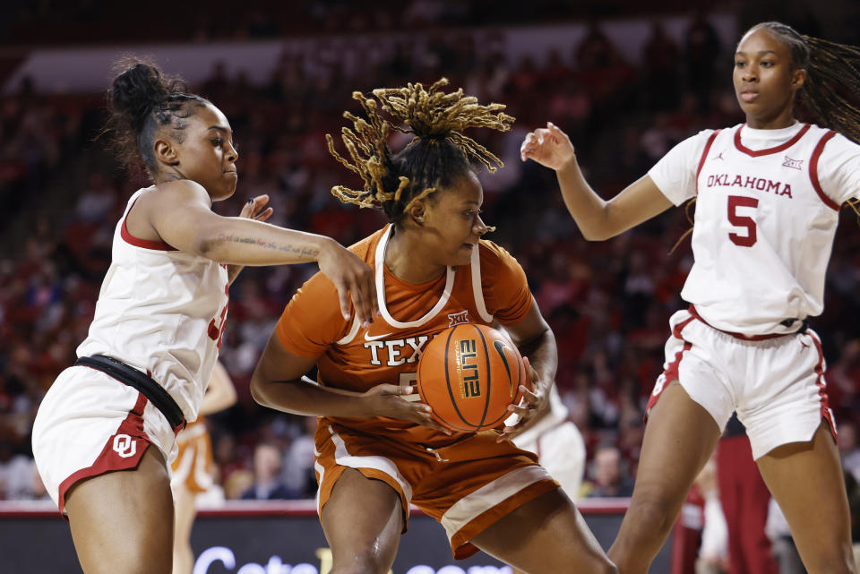 Texas forward DeYona Gaston, center, goes against Oklahoma forward Sahara Williams, left, and forward Kiersten Johnson, right, during the first half of an NCAA college basketball game Wednesday, Feb. 28, 2024, in Norman, Okla. (AP Photo/Garett Fisbeck)