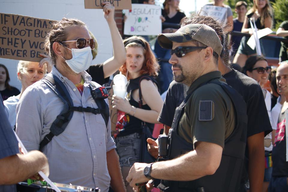 Protesters talk with a private security guard June 27 outside the Women's Care Center. The crowd was waiting for the center's employees to leave work at 4:30 p.m.