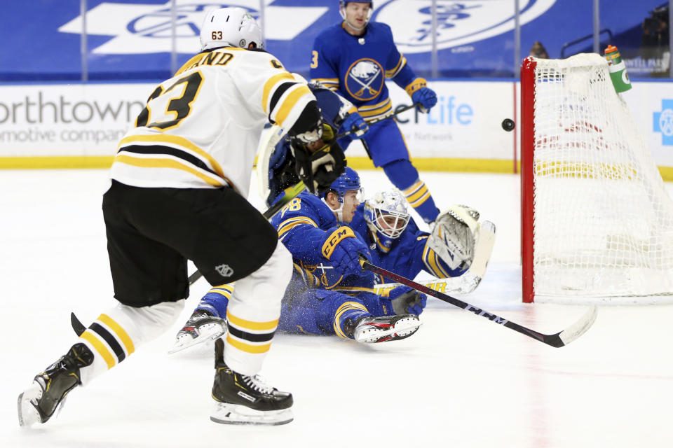 Boston Bruins forward Brad Marchand (63) puts the puck past Buffalo Sabres goalie Dustin Tokarski (31) during the first period of an NHL hockey game, Thursday, April 22, 2021, in Buffalo, N.Y. (AP Photo/Jeffrey T. Barnes)