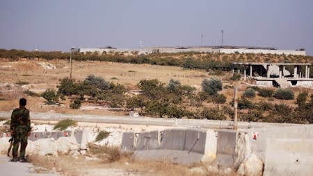 A Syrian army soldier stands near the Turkish observation point in the town of Morek, Hama district