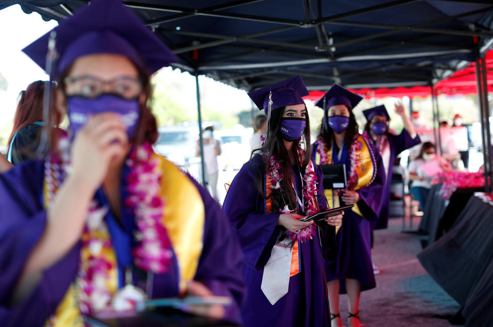 Compton Early College High School graduating students wait after picking up their diplomas in a parking lot during a drive-thru graduating ceremony, during the outbreak of the coronavirus disease (COVID-19) in Compton, California U.S. June 10, 2020. REUTERS/Mario Anzuoni