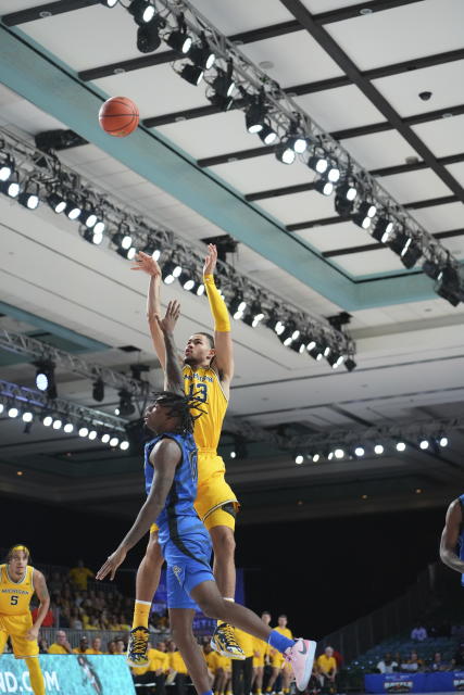 Michigan's Olivier Nkamhoua shoots over Memphis's Jaykwon Walton during the first half of an NCAA college basketball game in the Battle 4 Atlantis at Paradise Island, Bahamas, Wednesday, Nov. 22, 2023. (Ronnie Archer/Bahamas Visual Services via AP)