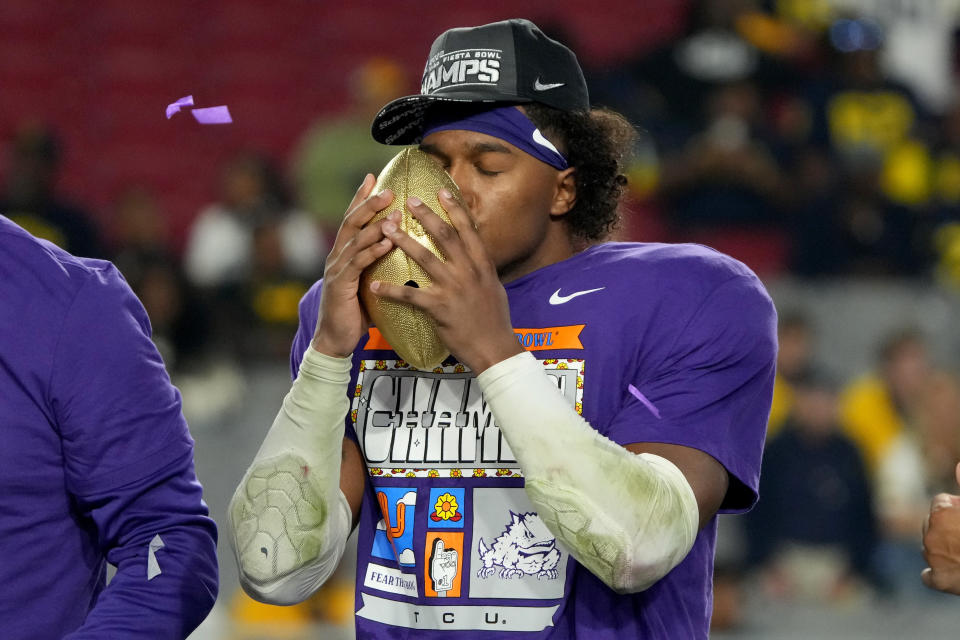 TCU linebacker Dee Winters kisses the trophy after the Fiesta Bowl NCAA college football semifinal playoff game, Saturday, Dec. 31, 2022, in Glendale, Ariz. TCU defeated Michigan 51-45. (AP Photo/Rick Scuteri)