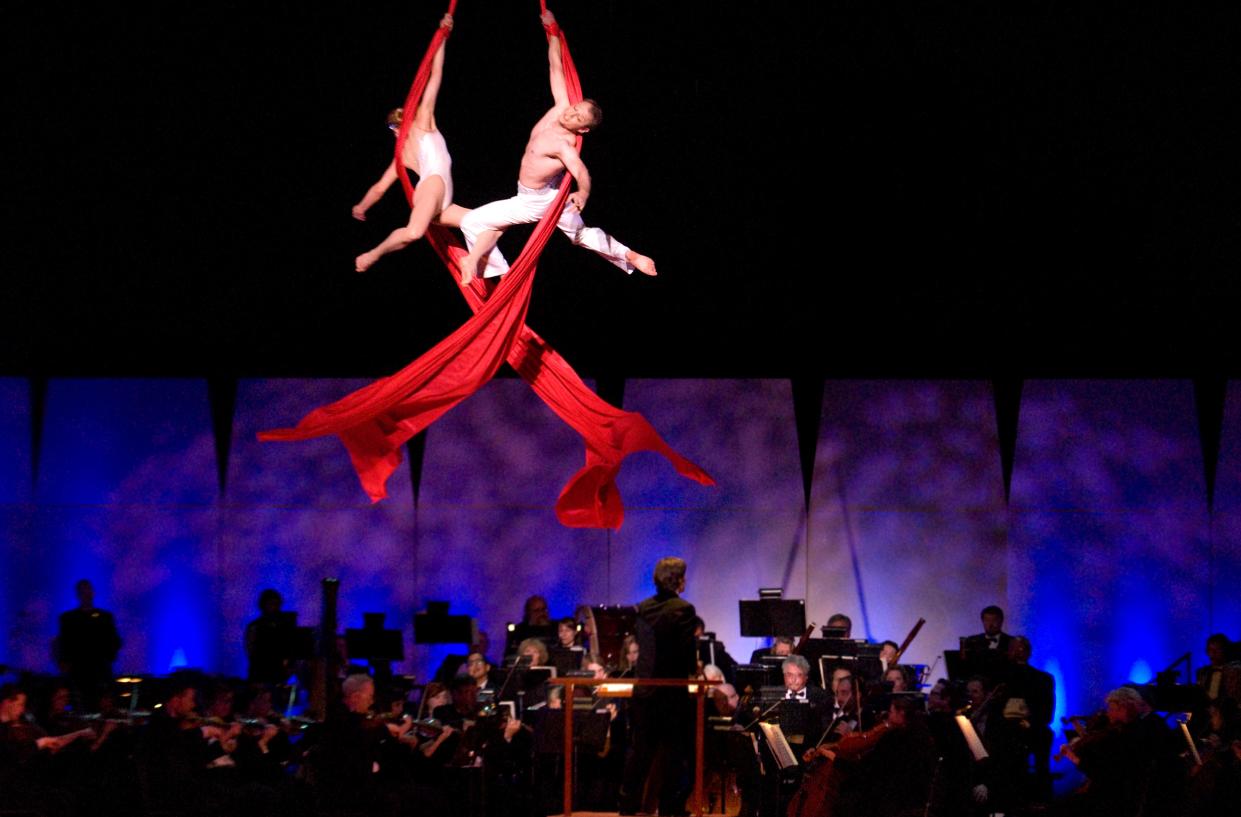 An aerial duo from Cirque de le Symphonie performs above a full orchestra of musicians performing. The Salina Symphony is bringing the touring troupe of artists back to the city for a visual and aural experience with "Cirque Goes to the Movies" this Saturday.