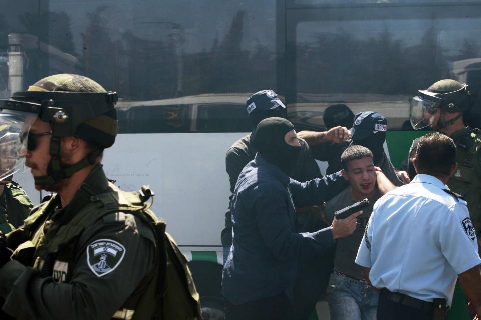 Undercover Israeli policemen detain a Palestinian during clashes following Friday prayers near Jerusalem's Old City