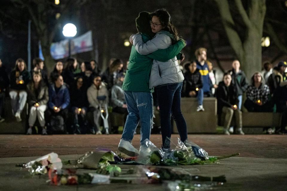 Two people hugged after leaving flowers at the Diag before a candlelight vigil for MSU shooting victims in Ann Arbor on Wednesday, Feb. 15, 2023.