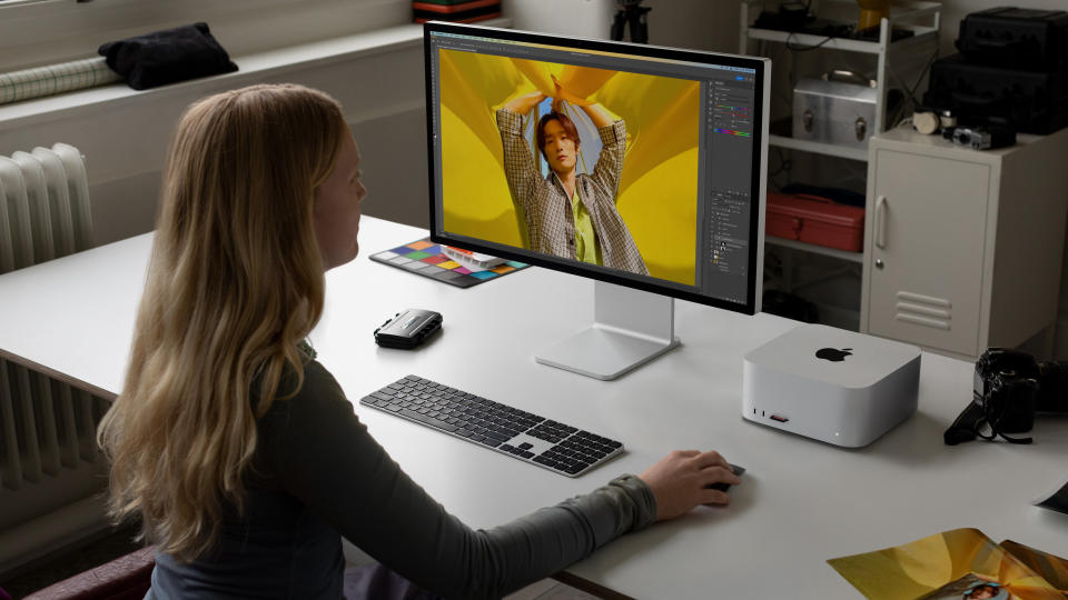 A woman designing a picture while using a Mac Studio 2023 at their desk