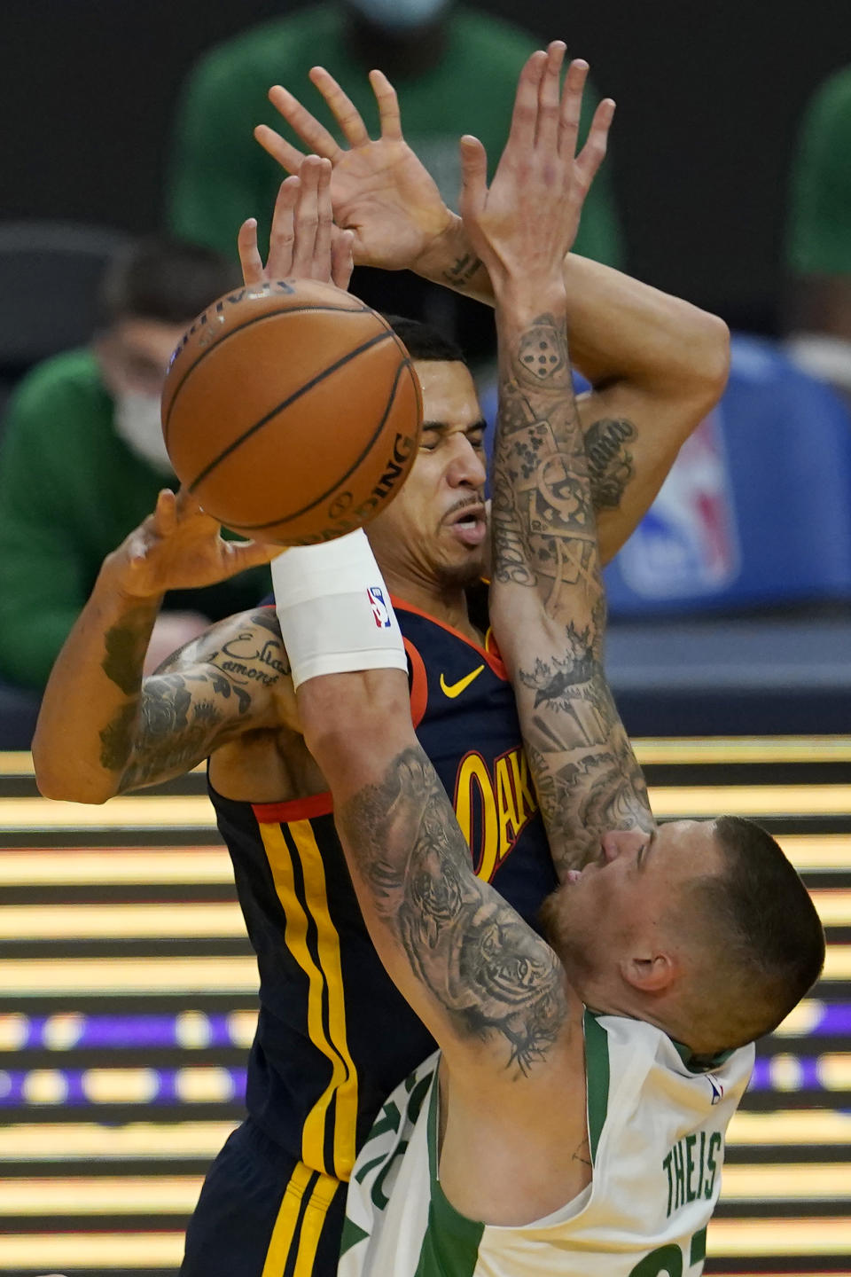 Golden State Warriors forward Juan Toscano-Anderson, top, passes the ball while defended by Boston Celtics center Daniel Theis during the first half of an NBA basketball game in San Francisco, Tuesday, Feb. 2, 2021. (AP Photo/Jeff Chiu)