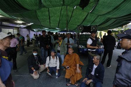 Thai Buddhist monk and anti-government protest leader Luang Pu Buddha Isara sits among other anti-government protesters blocking a district office where election materials are stored, after a gunfight between supporters and opponents of Thailand's government in Laksi, Bangkok February 1, 2014. REUTERS/Damir Sagolj