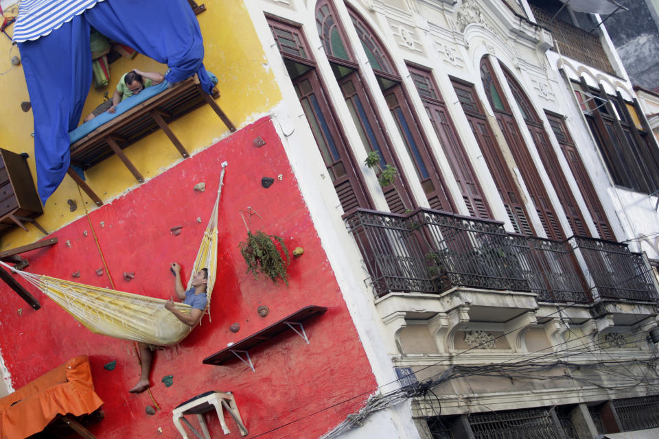 Brazilian artists Tiago Primo (top) and his brother Gabriel hang out at a wall in Rio de Janeiro July 8, 2009. The bizarre vertical "house" built on a climbing wall by Brazilian artists has been drawing the attention of thousands who walk by the installation in Rio de Janeiro's downtown neighbourhood. REUTERS/Bruno Domingos (BRAZIL SPORT SOCIETY) FOR BEST QUALITY IMAGE ALSO SEE: GM1E59F1QI101 - RTR25GTH