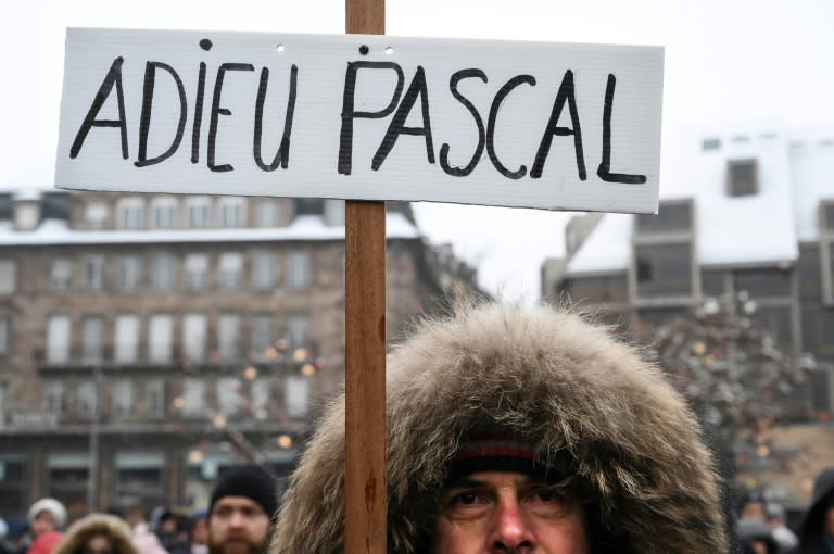 A mourner holds a sign reading "Farewell Pascal" at Saturday's ceremony, in reference to one of the five people killed in the attack