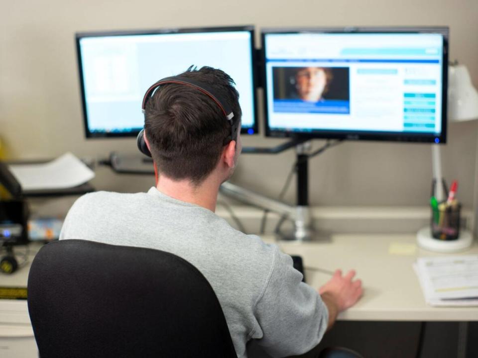 A file photo shows a person at a computer offering tele-health services. (811 Nova Scotia - image credit)