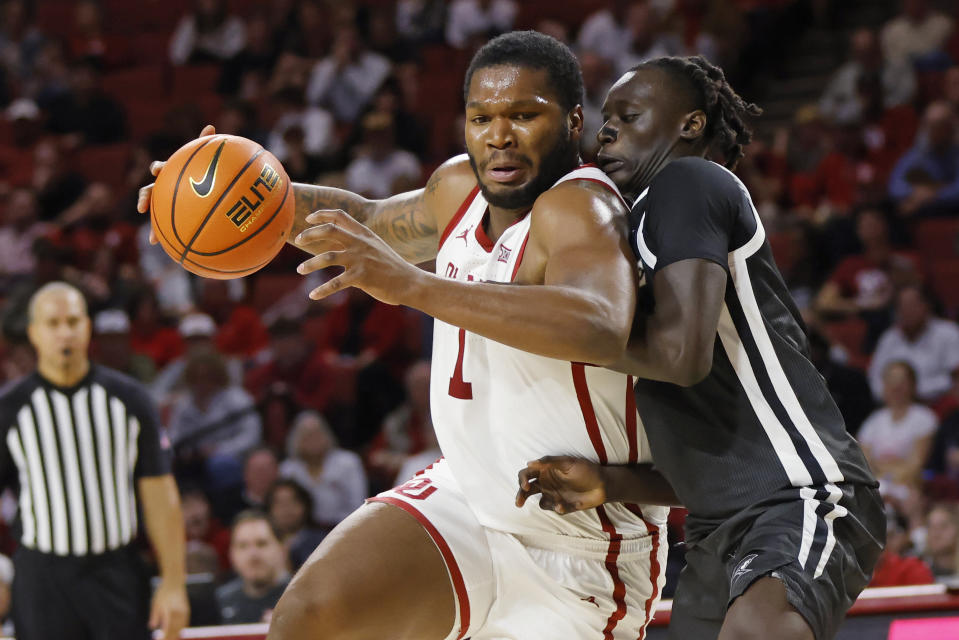 Oklahoma forward John Hugley IV, left, drives against Providence guard Garwey Dual, right, during the second half of an NCAA college basketball game, Tuesday, Dec. 5, 2023, in Norman, Okla. (AP Photo/Nate Billings)