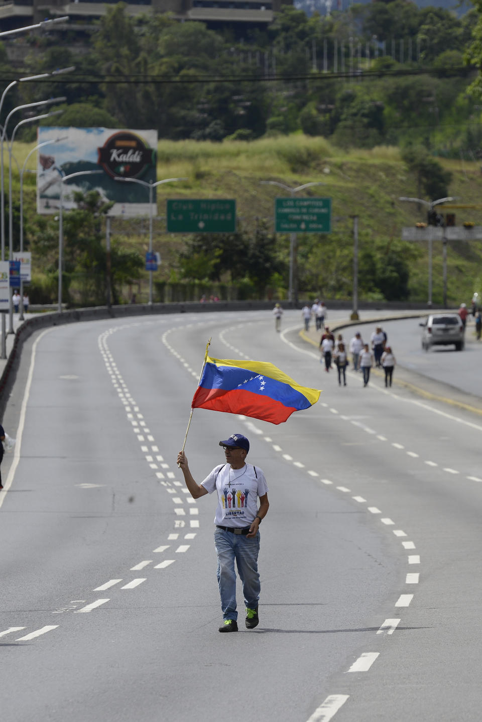 An opponent to President Nicolas Maduro walks along a highway in Caracas, Venezuela, Saturday, Nov. 16, 2019. Opposition leader Juan Guaido has called on Venezuelans across the nation to flood the streets for protests nearly a year after he launched his campaign to push Maduro from power. (AP Photo/Matias Delacroix)