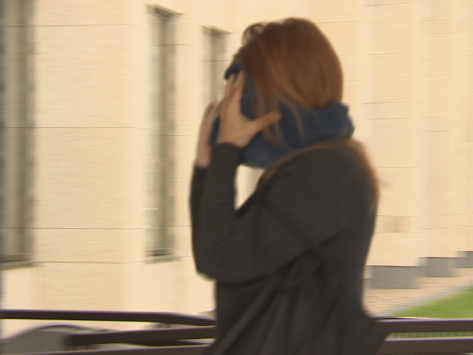 Alena Pastuch shielding her face from cameras as she enters court on Tuesday, July 11, 2017. She was convicted of fraud in 2019, but this week judges ordered a new trial. (CBC - image credit)