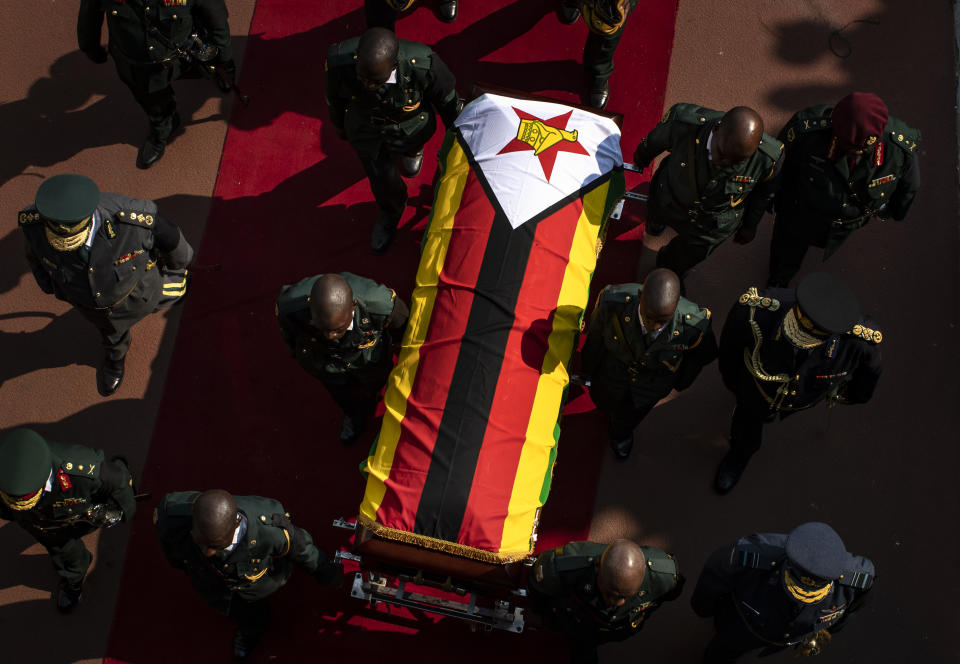 The casket of former president Robert Mugabe is escorted by military officers as it departs after a state funeral at the National Sports Stadium in the capital Harare, Zimbabwe Saturday, Sept. 14, 2019. African heads of state and envoys gathered to attend a state funeral for Zimbabwe's founding president, Robert Mugabe, whose burial has been delayed for at least a month until a special mausoleum can be built for his remains. (AP Photo/Ben Curtis)