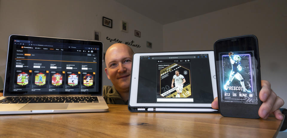 NFT trading card collector Christian Feule shows his collection on his various devices in Germany in 2021. (Peter Kneffel / dpa via AP file)