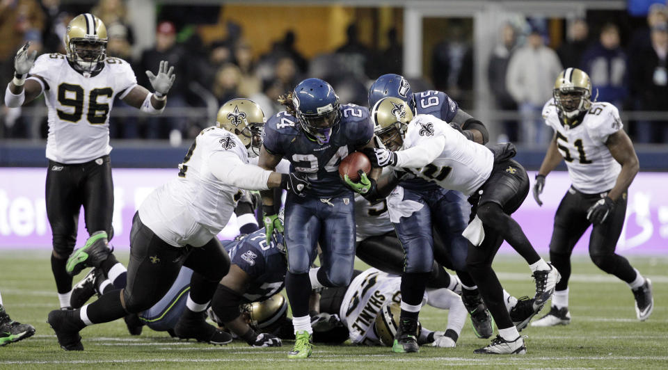 Seattle Seahawks' Marshawn Lynch (24) breaks away from a tackle by the New Orleans Saints defenders to score a touchdown in the second half of an NFL NFC wild card playoff football game, Saturday, Jan. 8, 2011, in Seattle. (AP Photo/Elaine Thompson)