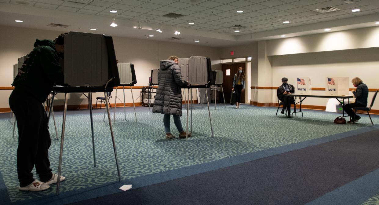 People fill out their absentee ballots Monday, Nov. 2, 2020, at Hannah Community Center in East Lansing, one day before the election.