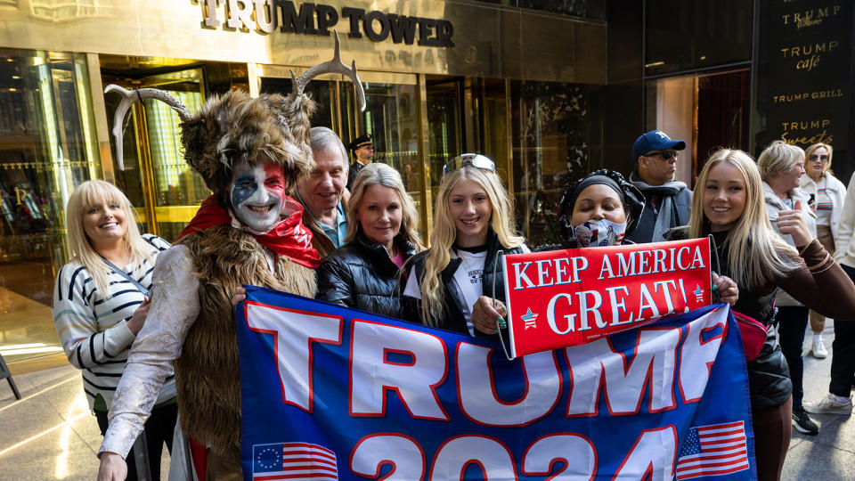 <b>Supporters of former President Trump pose with a demonstrator who identifies himself as Steven Daniel Wolverton (dressed like the Q-Anon Shaman) outside Trump Tower on March 21, 2023, in New York City.</b> Alexi Rosenfeld/Getty Images