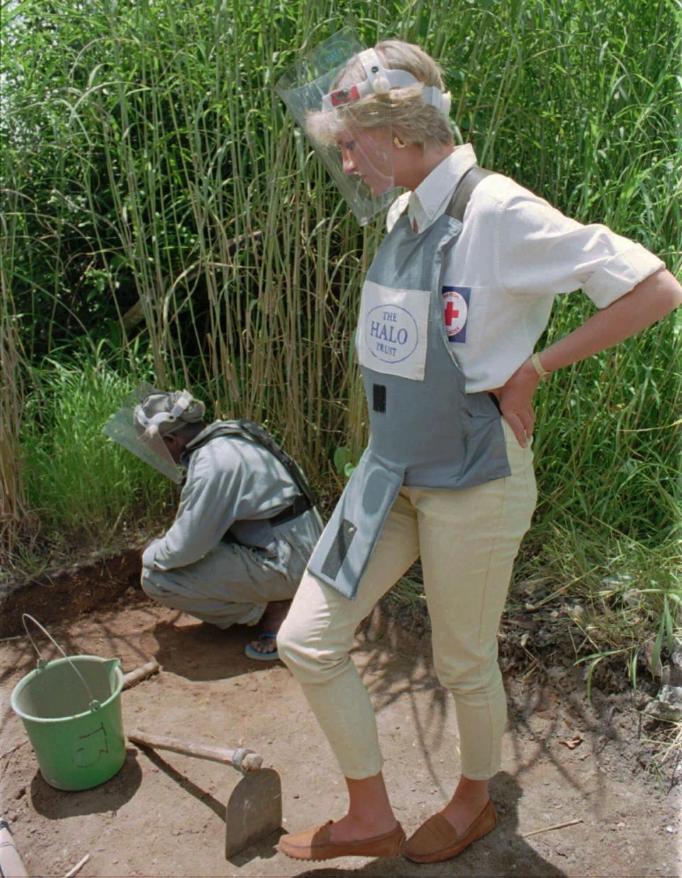 ARCHIVO – En esta fotografía del 15 de enero de 1997 Diana, la princesa de Gales con equipo protector observa una demostración de retiro de minas terrestres en Huambo, Angola, una de las zonas con más minas terrestres del país. La princesa Diana, que era considerada tímida al saltar a la fama, se convirtió en una revolucionaria en sus años en la Casa de Windsor modernizando la monarquía como una institución más personal y cambiando la forma en la que la familia real se relacionaba con la gente. (Foto AP/Giovanni Diffidenti, archivo)