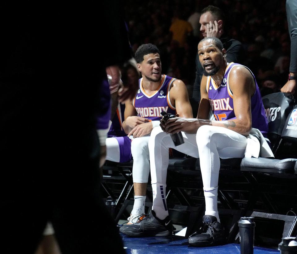 Phoenix Suns guard Devin Booker (1) and Phoenix Suns forward Kevin Durant (35) talk during a timeout during the second quarter of the Western Conference semifinals at Ball Arena in Denver on May 9, 2023.