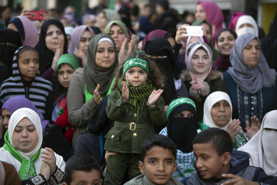 A Palestinian girl, center, wears a headband with Arabic that reads: "No God but Allah and Muhammed is his messenger, al-Qassam Brigades" during a mass rally marking the 32nd anniversary of the founding of Hamas, an Islamic political party, which has an armed wing of the same name, that currently rules in Gaza, Saturday, Dec. 14, 2019, in Gaza city. (AP Photo/Khalil Hamra)