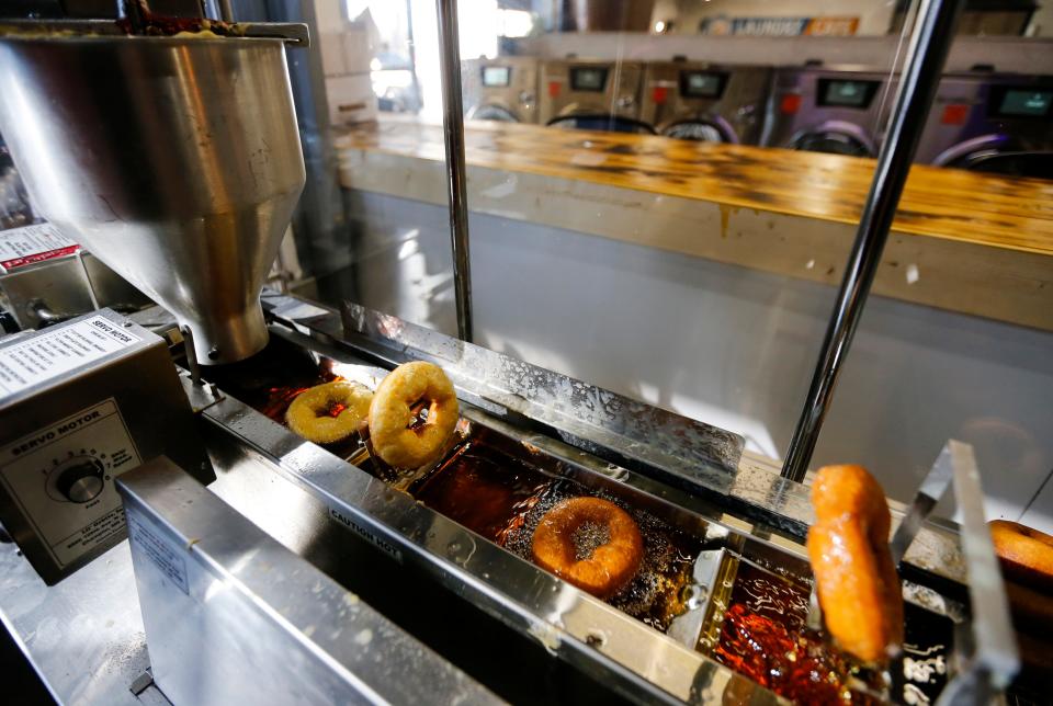 A machine makes donuts at the The Washboard Cafe on Wednesday, March 29, 2023.