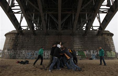 Men practise their skills under a bridge during a training session of paramilitary guards ahead of Poland's National Independence Day march in Warsaw November 3, 2013. REUTERS/Kacper Pempel