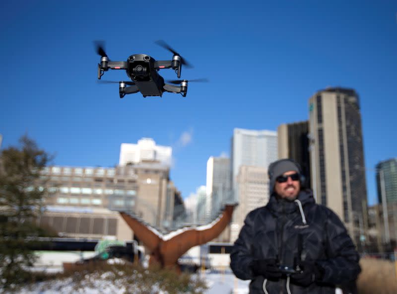 FILE PHOTO: A drone operator flies his drone as Chinese drone maker DJI holds a demonstration to display an app that tracks a drone's registration and owner in Montreal