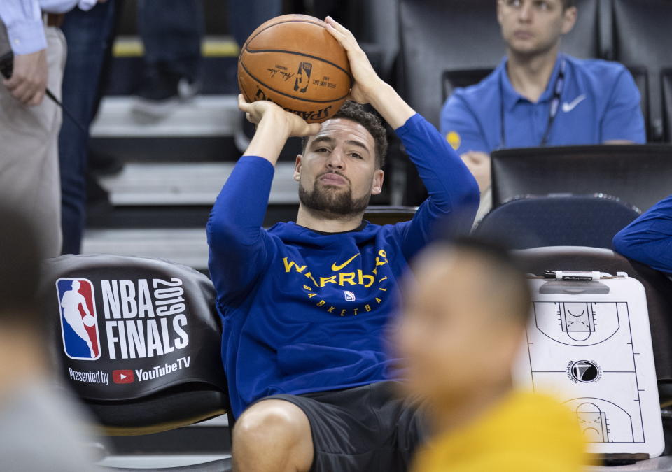 Golden State Warriors' Klay Thompson practices his shot motion as he sits on the bench watching teammates during practice for the NBA Finals against the Toronto Raptors Tuesday, June 4, 2019, in Oakland, Calif. Game 3 of the NBA Finals is Wednesday, June 5, 2019, in Oakland, Calif. (Frank Gunn/The Canadian Press via AP)