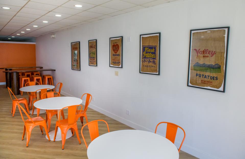 Framed potato sacks hang on the wall in the large dining area available at the new Tadoughs location in the Tanglewood Shopping Center in Peoria.