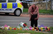 A woman lays flowers on Sheepstor Road in Plymouth (Ben Birchall/PA) (PA Wire)
