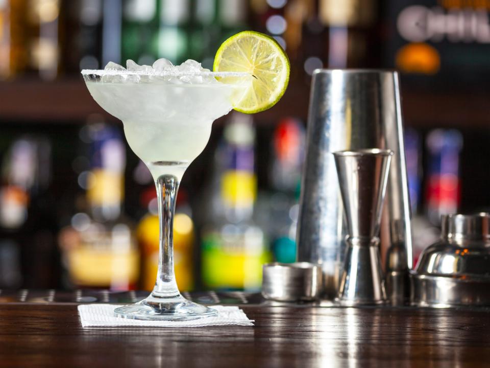classic lime margarita sitting on a bar