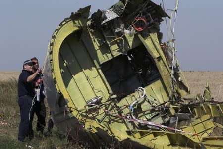 Members of a group of international experts inspect wreckage at the site where the downed Malaysia Airlines flight MH17 crashed, near the village of Hrabove (Grabovo) in Donetsk region, eastern Ukraine August 1, 2014. REUTERS/Sergei Karpukhin