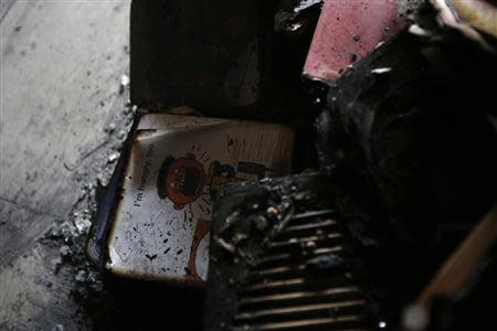 An English textbook is seen among debris at a dining room of a migrant shelter destroyed by an arson attack in Seoul October 14, 2013. REUTERS/Kim Hong-Ji