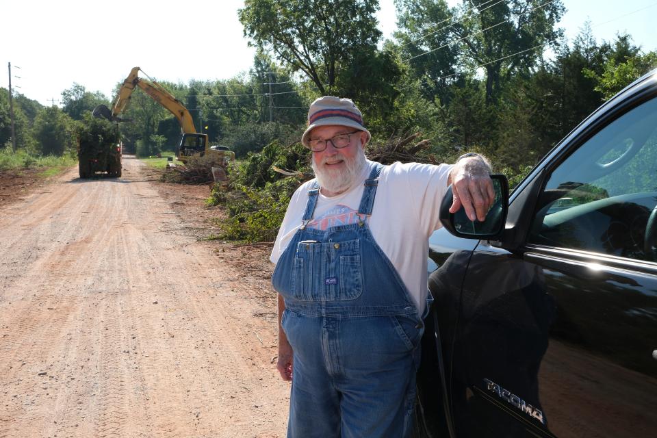 Logan County Commissioner Charlie Meadows posses near where trees are being cleared in a paving and widening project on Simmons Rd as preparation for the Waterloo Rd widening project between Logan and Oklahoma County. Friday, Aug. 11, 2023