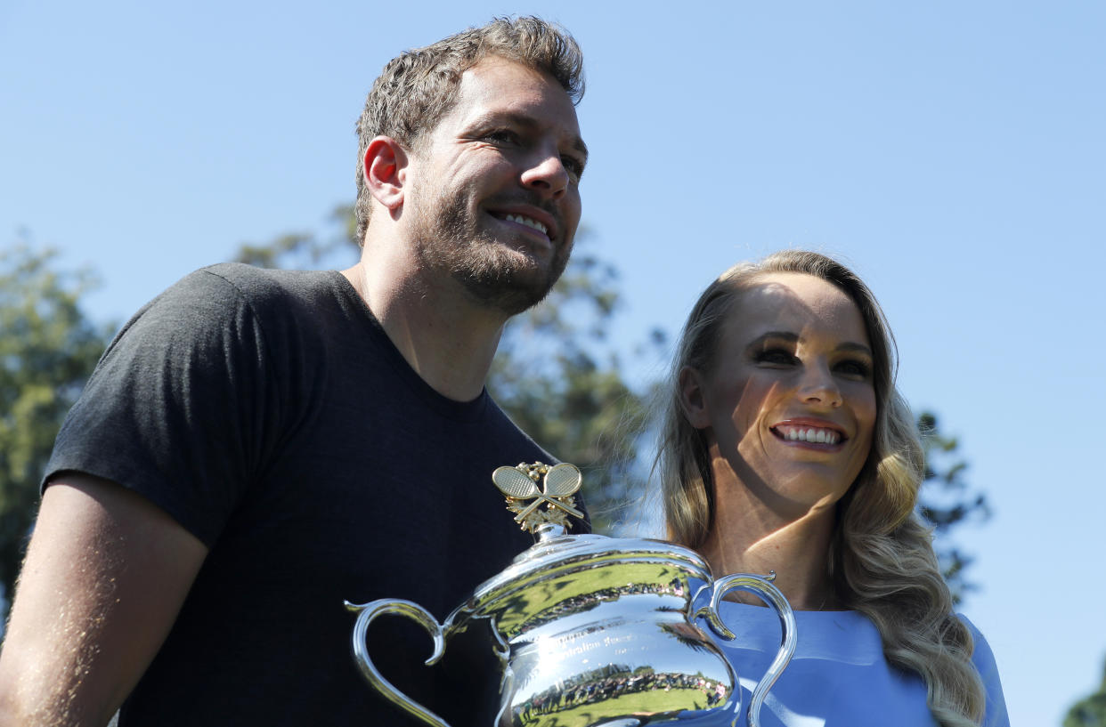 Denmark's Caroline Wozniacki and fiance' David Lee with her Australian Open trophy, the Daphne Akhurst Memorial Cup in the Royal Botanical Gardens in Melbourne, Australia, Sunday, Jan. 28, 2018. Wozniacki defeated Romania's Simona Halep 7-6, 3-6, 6-4 in Saturday's final.(AP Photo/Ng Han Guan)