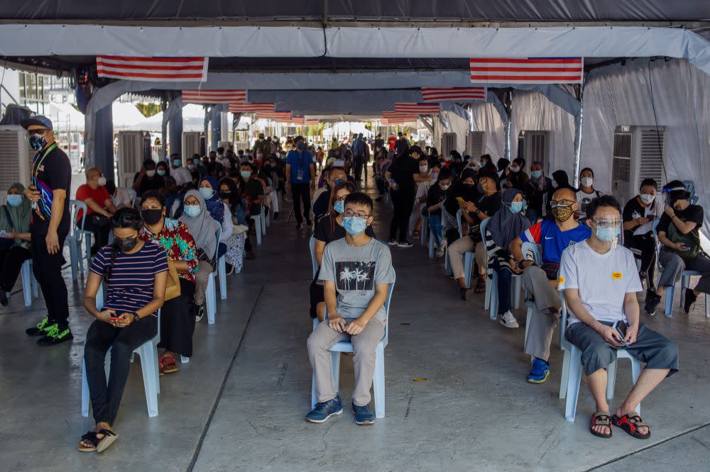 People queue as they wait to receive their Covid-19 jab at the Axiata Arena in Bukit Jalil September 23, 2021. — Picture by Shafwan Zaidon