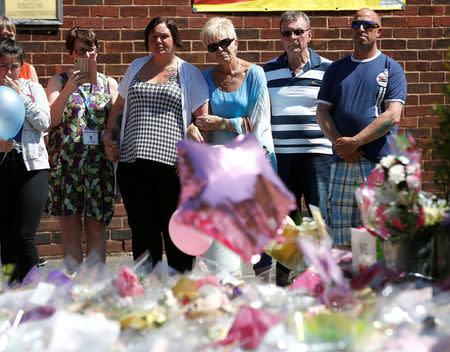 Charlotte Campbell (4th R) looks at flowers outside Tottington high school, in memory of her daughter Olivia Campbell who was killed during the Manchester Arena attack, Bury, Manchester, Britain, May 26, 2017. REUTERS/Andrew Yates